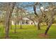 Quaint home framed by mature trees and a sprawling lawn, offering a serene setting at 30041 Redoak Ave, Eustis, FL 32736