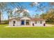 Charming single-story home featuring a bright blue front door, pretty landscaping, and a welcoming front patio at 30041 Redoak Ave, Eustis, FL 32736