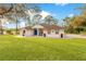 Charming single-story home with a blue front door, manicured lawn, and mature trees at 30041 Redoak Ave, Eustis, FL 32736