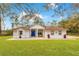 Inviting single-story house featuring a bright blue door, lush green lawn, and brick walkway at 30041 Redoak Ave, Eustis, FL 32736