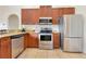Well-equipped kitchen with stainless steel appliances, wood cabinets, and granite countertops at 30041 Redoak Ave, Eustis, FL 32736