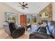 Comfortable living room featuring a stone fireplace, seating, and natural light at 30041 Redoak Ave, Eustis, FL 32736