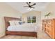 Bright and airy main bedroom with tile floors, featuring a comfortable bed, natural light, and a peaceful ambiance at 30041 Redoak Ave, Eustis, FL 32736