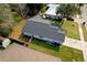 An aerial view shows the roof of a home with a manicured lawn and a fenced yard at 3106 Garden Ct, St Cloud, FL 34769