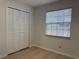 Bright bedroom features a bi-fold door closet and a sunlit window with horizontal blinds at 3106 Garden Ct, St Cloud, FL 34769