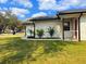 View of the front yard with young palms, a bright red front door, and fresh landscaping at 3106 Garden Ct, St Cloud, FL 34769