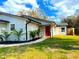 Charming single-story home with a well-manicured lawn and a vibrant red front door at 3106 Garden Ct, St Cloud, FL 34769