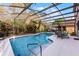 Screened-in pool area with ample seating, landscaping, and a covered enclosure at 3121 Bellingham Dr, Orlando, FL 32825