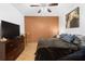 Bedroom features a ceiling fan, queen bed, tile flooring, and brown and white accent wall at 3403 Great Pond Dr, Kissimmee, FL 34746