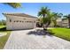 Charming home with a clay tile roof, lush landscaping, and a brick paved driveway leading to a two-car garage at 3403 Great Pond Dr, Kissimmee, FL 34746