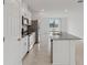 Open kitchen features white cabinets, granite countertops, island and backyard view at 4006 Copperleaf Ln, Poinciana, FL 34759
