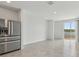 Spacious living space with tile floors, stainless steel refrigerator, and a view of the lake at 4006 Copperleaf Ln, Poinciana, FL 34759