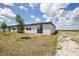 Backyard view of the house, showing well-maintained grass and nearby property at 4010 Copperleaf Ln, Poinciana, FL 34759