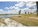 This property features a grassy lawn and a beautiful view of a nearby lake at 4010 Copperleaf Ln, Poinciana, FL 34759