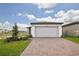 Modern home featuring a two-car garage, brick paver driveway, and a well-manicured lawn with fresh landscaping at 4010 Copperleaf Ln, Poinciana, FL 34759