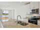 Modern kitchen featuring granite counters, stainless steel appliances, and view to the community lake at 4010 Copperleaf Ln, Poinciana, FL 34759
