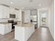 Bright kitchen with white cabinetry, granite counters, stainless steel appliances, and a large island at 4010 Copperleaf Ln, Poinciana, FL 34759