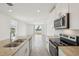 Modern kitchen with stainless steel appliances, granite countertops, and view to the living room at 4010 Copperleaf Ln, Poinciana, FL 34759
