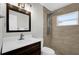 This bathroom features tiled walls and floors, walk-in shower and modern fixtures at 4127 Sanseviera Ln, Orlando, FL 32822