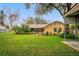 Expansive backyard view featuring lush green lawn, mature landscaping, and a screened-in porch at 4442 Glenview Ln, Winter Park, FL 32792