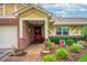 Inviting front porch with red door, brick columns, house number and colorful landscaping at 4442 Glenview Ln, Winter Park, FL 32792