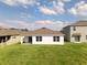 A view of the backyard with lush green grass and a home's rear exterior at 447 Talisi Loop, St Cloud, FL 34771