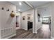 Hallway view showcasing hardwood flooring, hat rack, and access to laundry room at 447 Talisi Loop, St Cloud, FL 34771