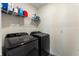 Efficient laundry room featuring a side-by-side washer and dryer set and storage shelving at 447 Talisi Loop, St Cloud, FL 34771