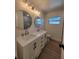 Bright bathroom featuring a double vanity with modern fixtures, circular mirrors, and a neutral color palette at 5153 Lido, Orlando, FL 32807