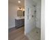 This bathroom features a marble tiled shower and grey vanity with gold hardware at 5153 Lido, Orlando, FL 32807