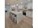 Modern kitchen featuring white cabinetry, quartz countertops, stainless steel appliances, and a large island with seating at 5153 Lido, Orlando, FL 32807