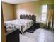 Simple bedroom featuring tiled floors, a large bed with a unique headboard, and natural light at 5622 Nokomis Cir, Orlando, FL 32839