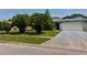 Charming single-story home with a well-manicured lawn and concrete driveway leading to the garage at 5622 Nokomis Cir, Orlando, FL 32839