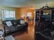 Cozy living room featuring hardwood floors, a comfortable leather couch, and entertainment center at 5622 Nokomis Cir, Orlando, FL 32839