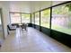 Enclosed sunroom featuring tile flooring, seating, and table set, with views of the outdoor yard at 5622 Nokomis Cir, Orlando, FL 32839