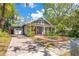 Charming bungalow with a brick driveway, mature landscaping, and inviting front porch at 647 E Livingston St, Orlando, FL 32803