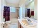 Neutral-toned bathroom featuring a bathtub with shower, a window, and a toilet with matching rug at 712 Timberwilde Ave, Winter Springs, FL 32708