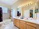 Bright bathroom featuring double sink vanity, a large mirror, and a shower-tub combo with neutral-toned tile at 712 Timberwilde Ave, Winter Springs, FL 32708