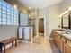 Bright bathroom featuring a glass block window, dual vanities, and a glass shower enclosure at 712 Timberwilde Ave, Winter Springs, FL 32708