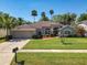 Charming single-story home boasts a well-manicured lawn, beautiful landscaping, and a classic stucco facade at 712 Timberwilde Ave, Winter Springs, FL 32708