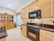 A well-equipped kitchen includes wooden cabinets, black appliances, tile backsplash and granite countertops at 712 Timberwilde Ave, Winter Springs, FL 32708