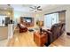 Living room with hardwood floors, ceiling fan, large tv, and comfortable leather furniture at 712 Timberwilde Ave, Winter Springs, FL 32708