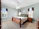 A main bedroom features carpet, a ceiling fan, light-blue painted walls, and natural light at 712 Timberwilde Ave, Winter Springs, FL 32708