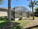 View of the screened lanai and lush landscaping from the exterior at 712 Timberwilde Ave, Winter Springs, FL 32708