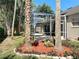 View of the screened lanai with outdoor seating and lush landscaping at 712 Timberwilde Ave, Winter Springs, FL 32708