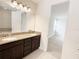 Double sink bathroom vanity with granite countertop, complemented by a tiled floor and an open doorway at 7417 Marker Ave, Kissimmee, FL 34747