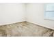 Simple bedroom with neutral carpet, base molding, and a window providing natural light at 7417 Marker Ave, Kissimmee, FL 34747