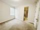 Bright bedroom featuring neutral walls, carpeted floor, closet, and a bathroom doorway at 7417 Marker Ave, Kissimmee, FL 34747