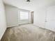 Bright bedroom featuring neutral walls, carpeted floor, closet, and a door at 7417 Marker Ave, Kissimmee, FL 34747