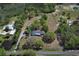 Overhead view of property featuring residence, outbuildings, pond, and pasture at 7435 Redwing Rd, Groveland, FL 34736